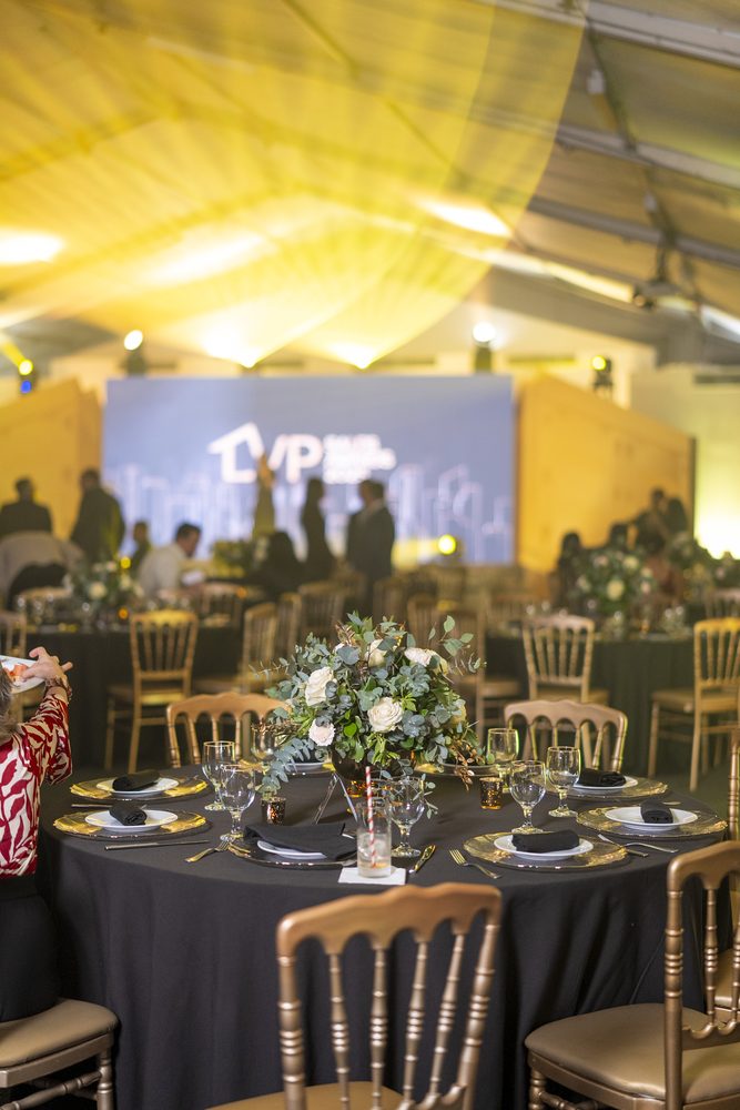 Mesas montadas bajo la luz dorada del salón de la gala.