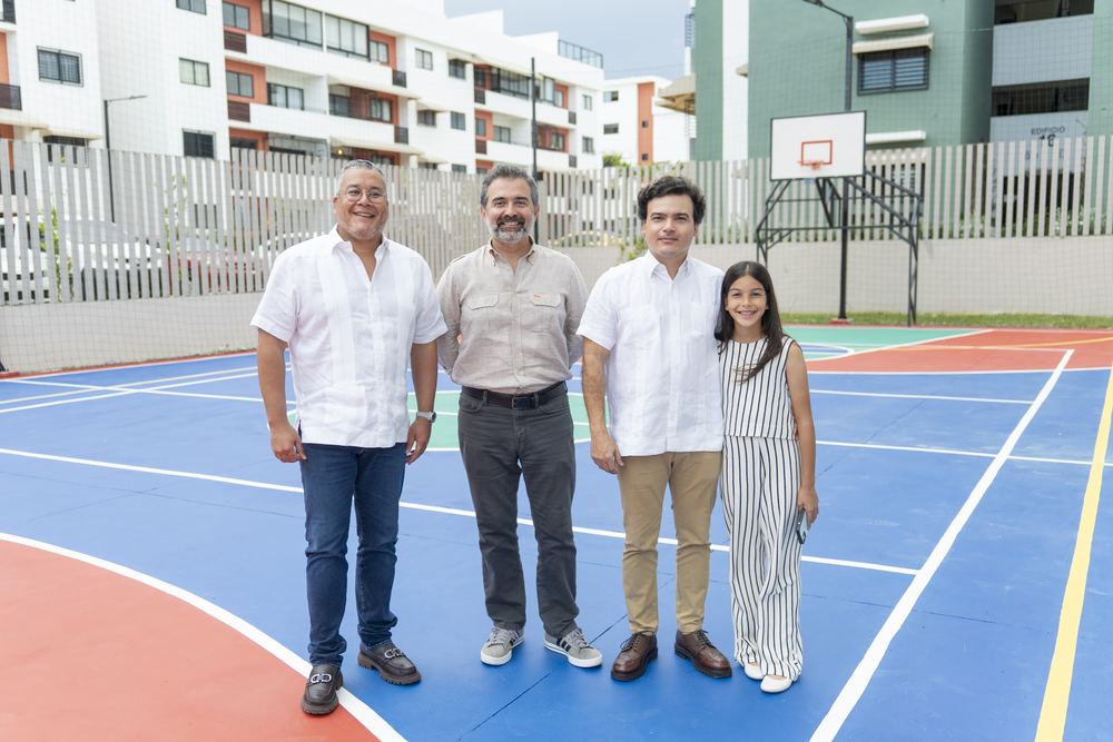 Grupo posando en la cancha multiuso de colores del residencial Riviera Verde.