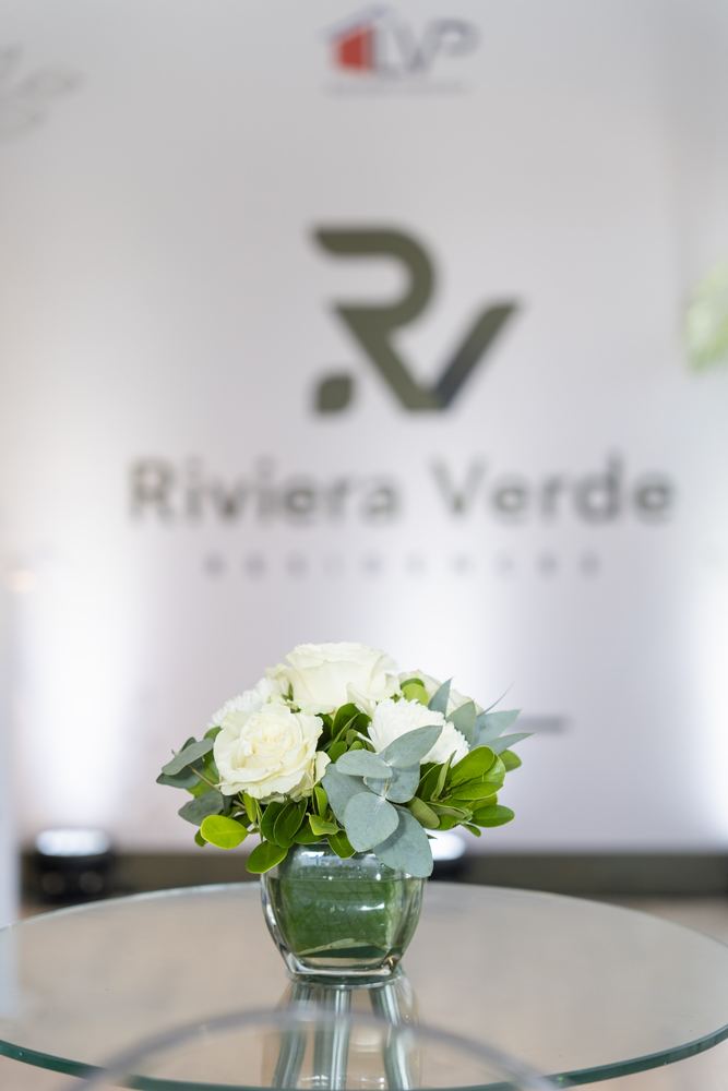 Backdrop de Riviera Verde Residences con arreglo de rosas blancas en primer plano.