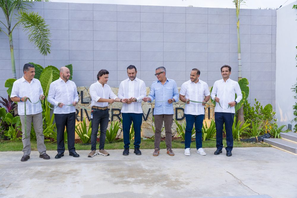 Directivos cortan la cinta inaugural frente al muro con el nombre de la casa club.
