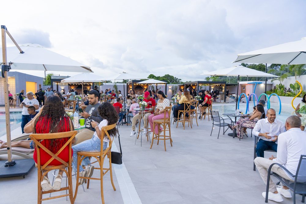 Invitados en la terraza junto a la piscina durante la apertura.